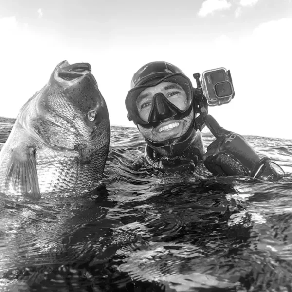 Pescasub con dentón señala un soporte vertical sujetado en la máscara de pesca submarina